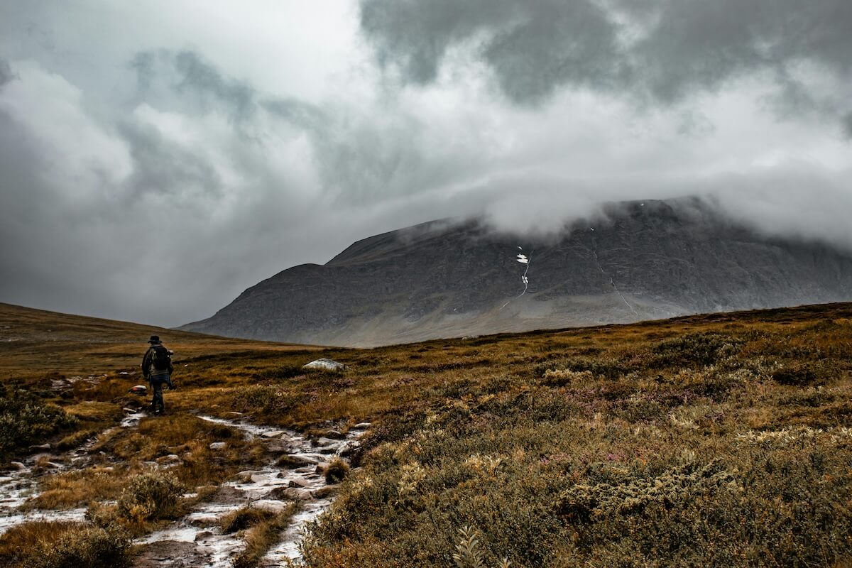 Solitary hiker traversing misty mountains in Trollheimen, Norway