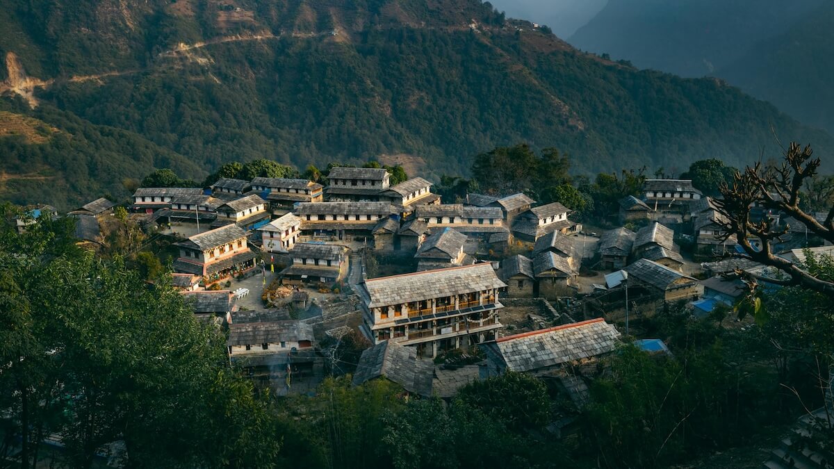 Aerial view of traditional houses clustered together in mountain village with terraced hillsides