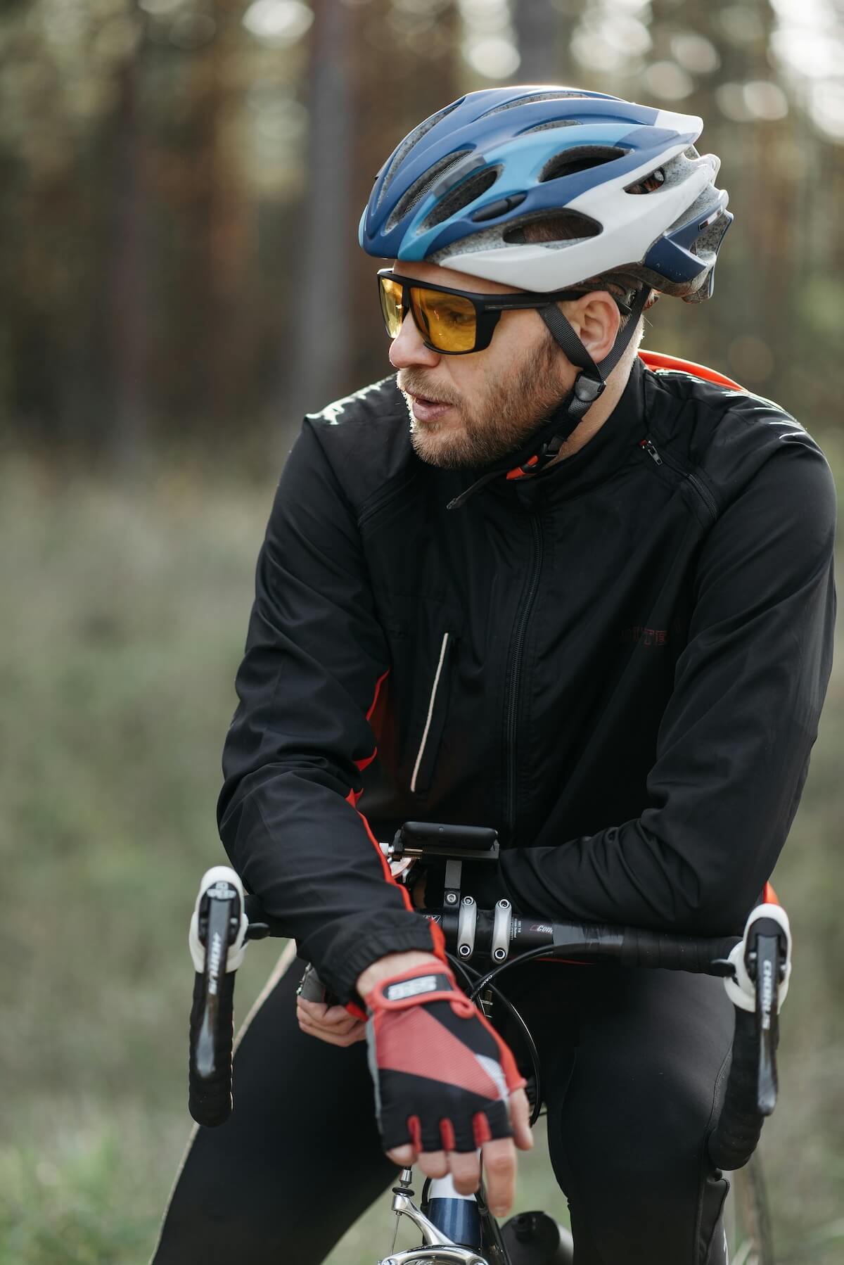 Cyclist wearing helmet and protective gear in forest setting