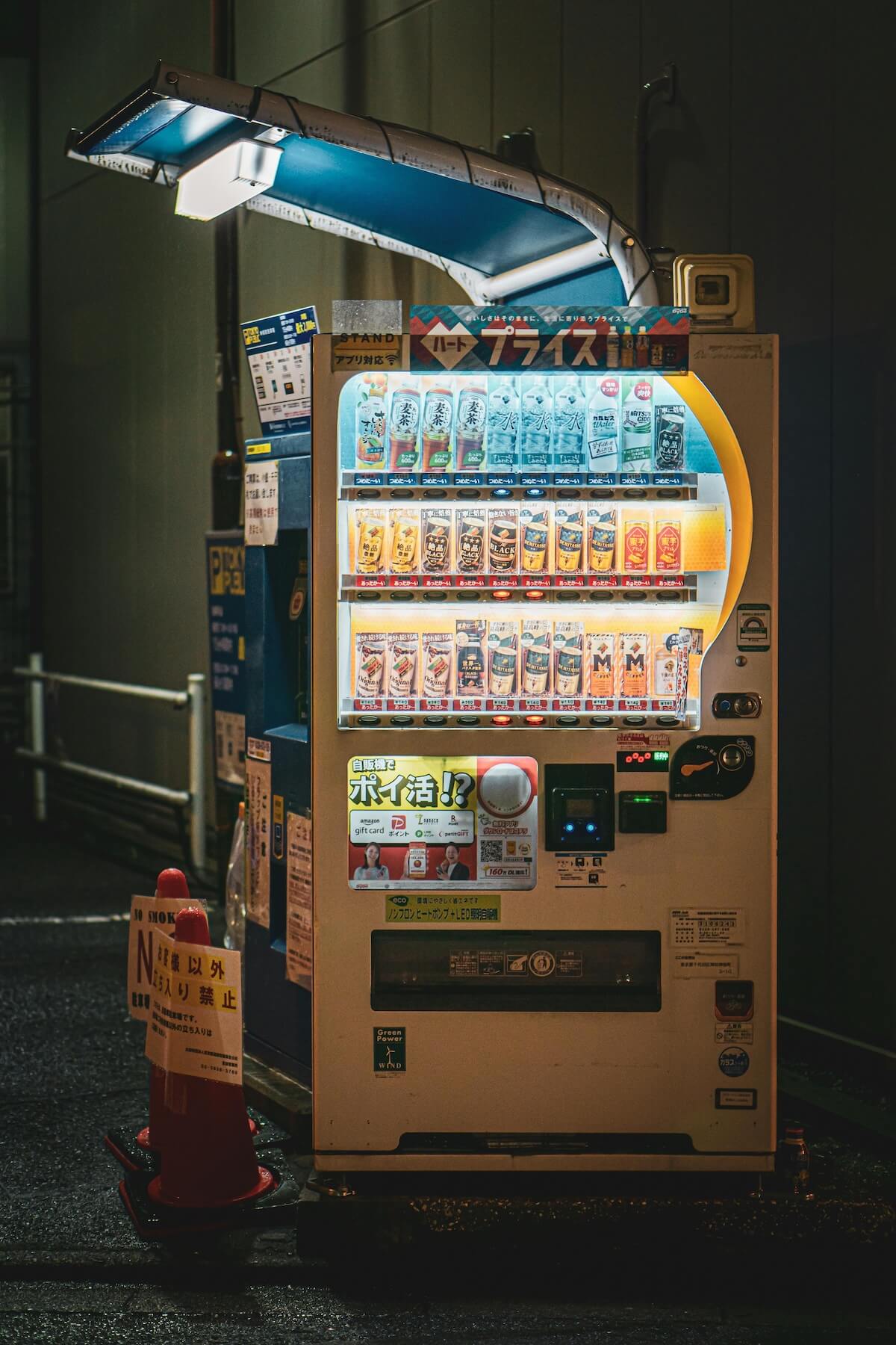 Illuminated beverage vending machine glowing on a Japanese street at night