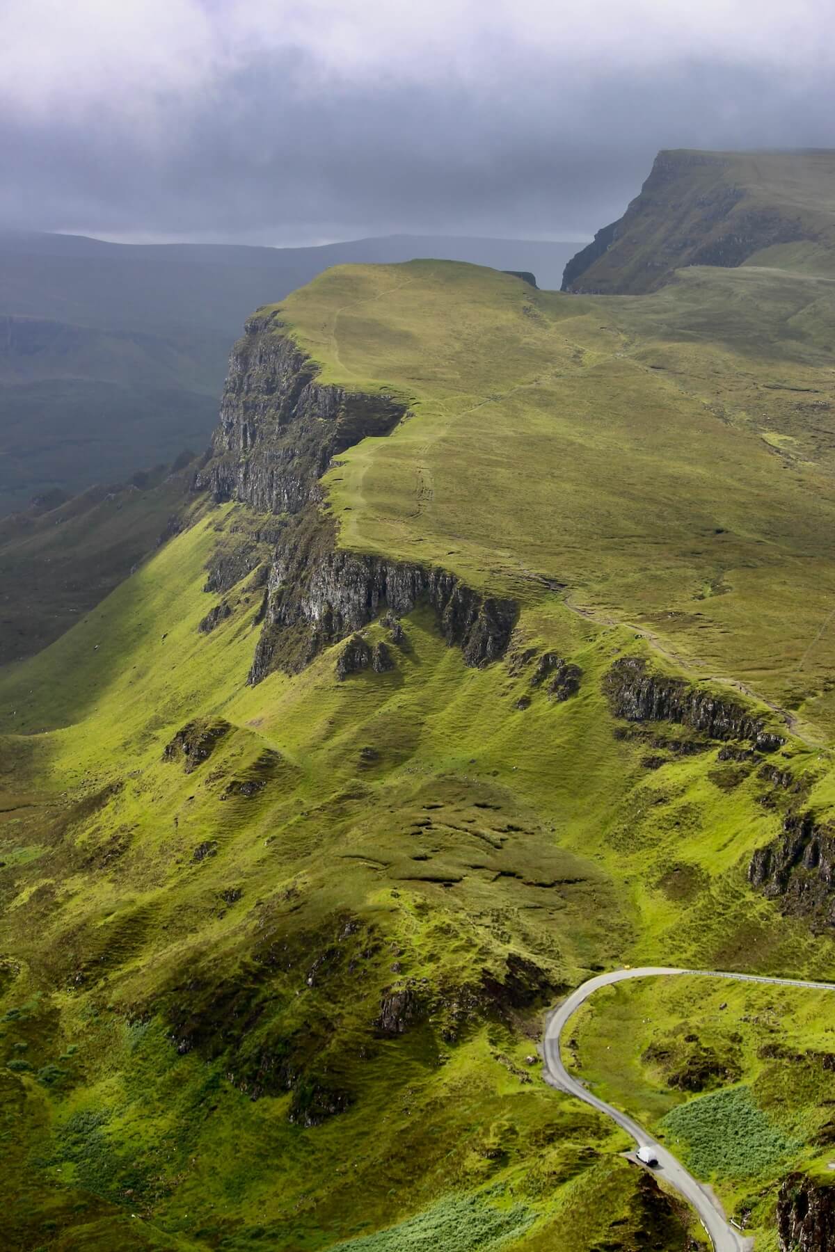 Winding road through the mountains on the Isle of Skye with dramatic green hills