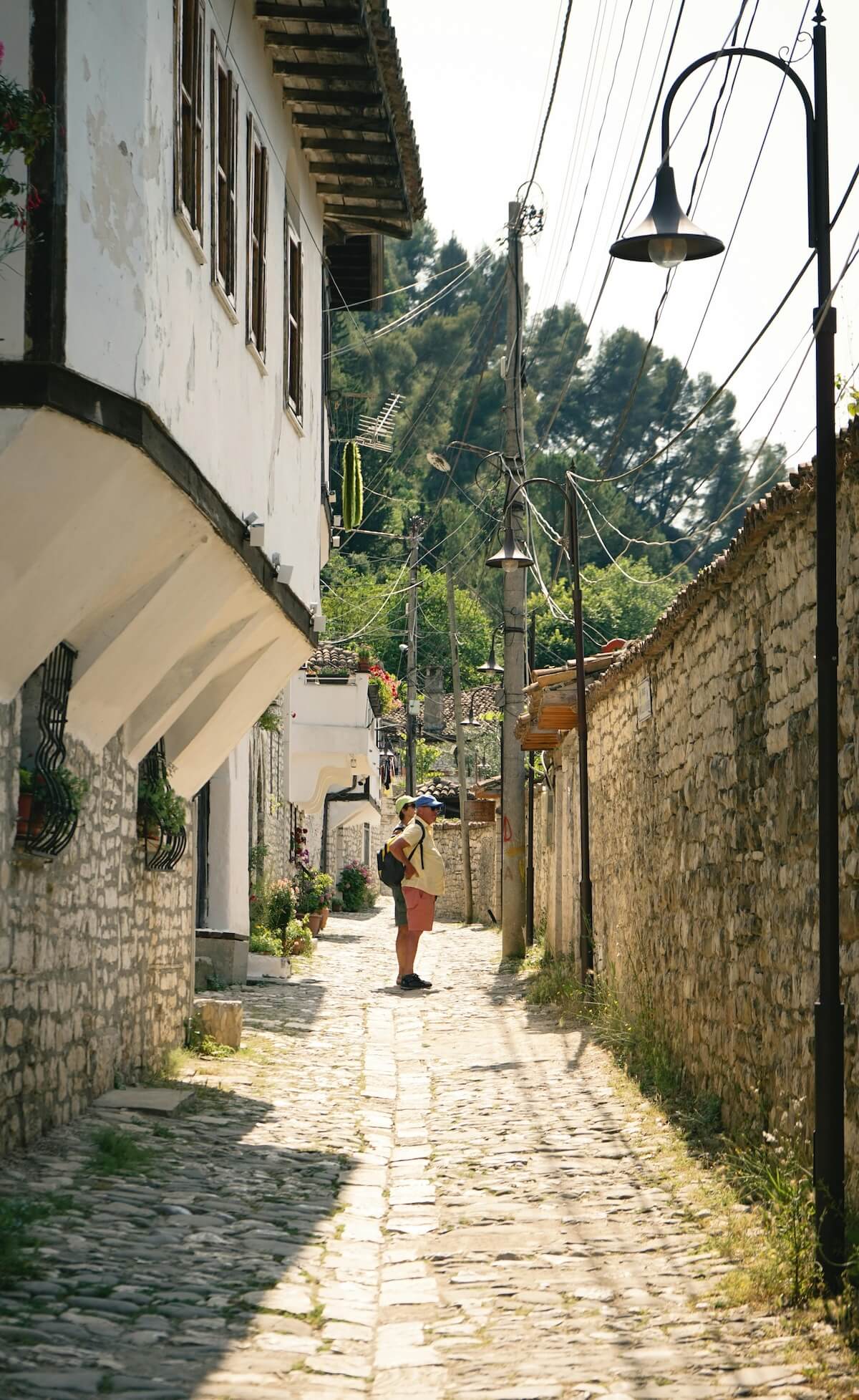 Tourist exploring cobblestone street in historic Berat, Albania