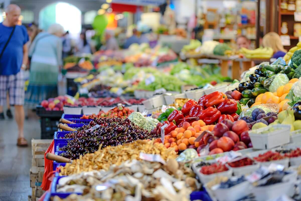 Colorful assortment of fresh fruits and vegetables at a bustling outdoor market