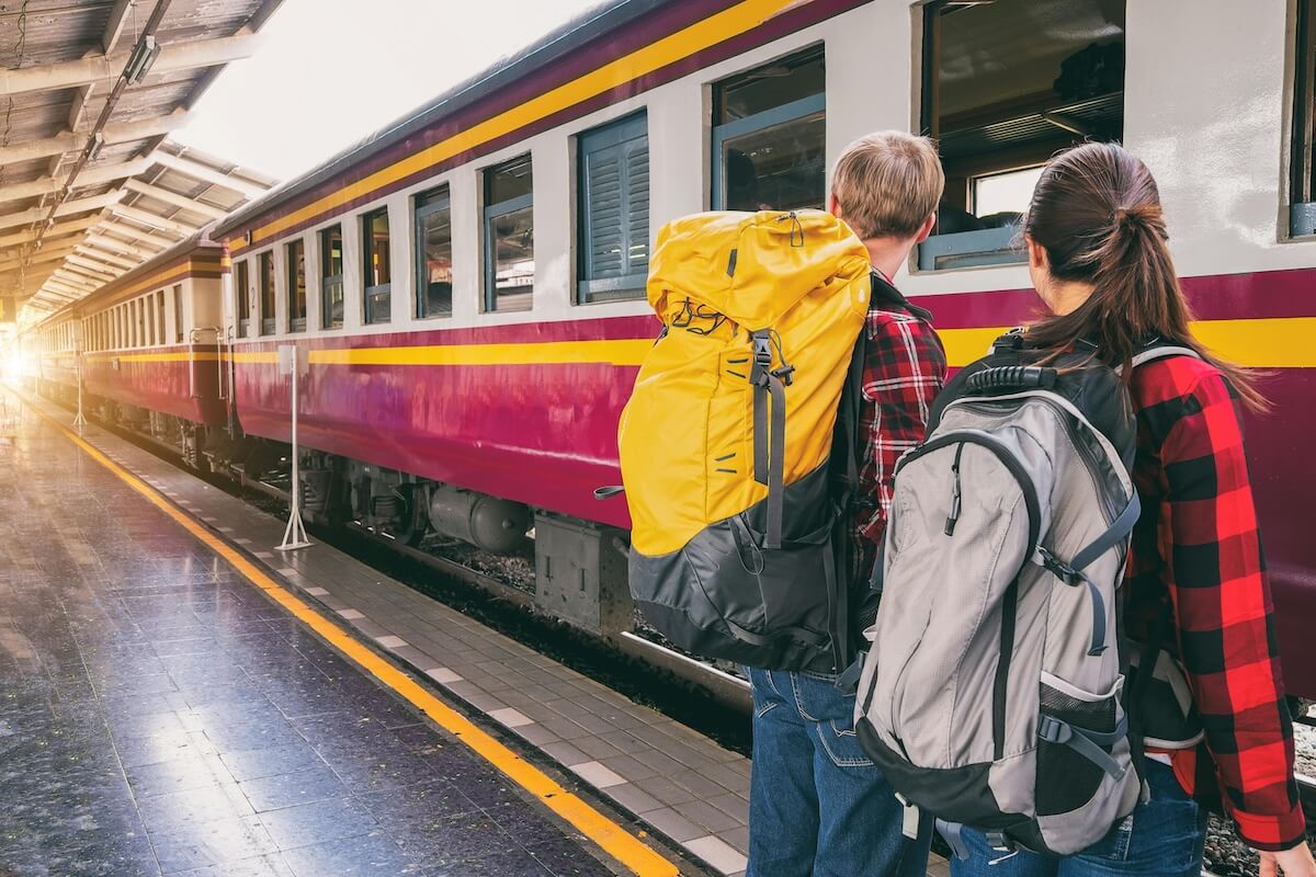 Backpackers waiting at train station platform ready for travel