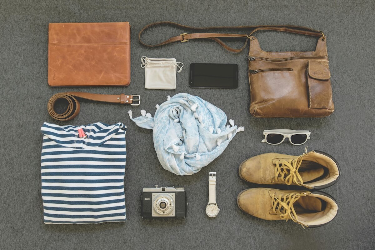 Vintage travel flat lay with leather bags, shoes and camera
