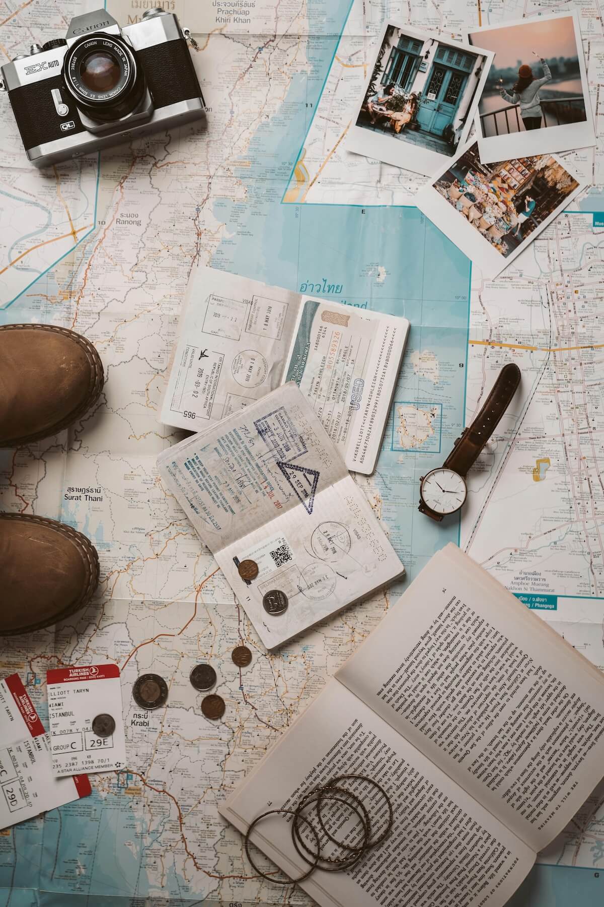 Travel flat lay with camera, map, passport and boots