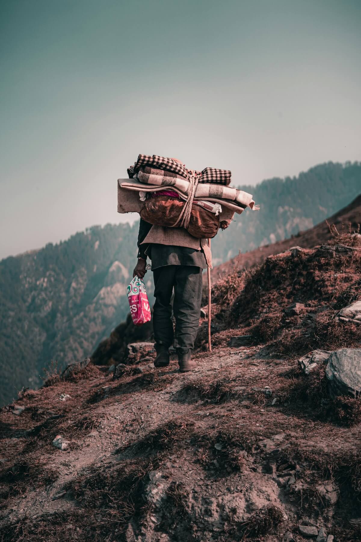 Hiker with backpack trekking through mountain trail
