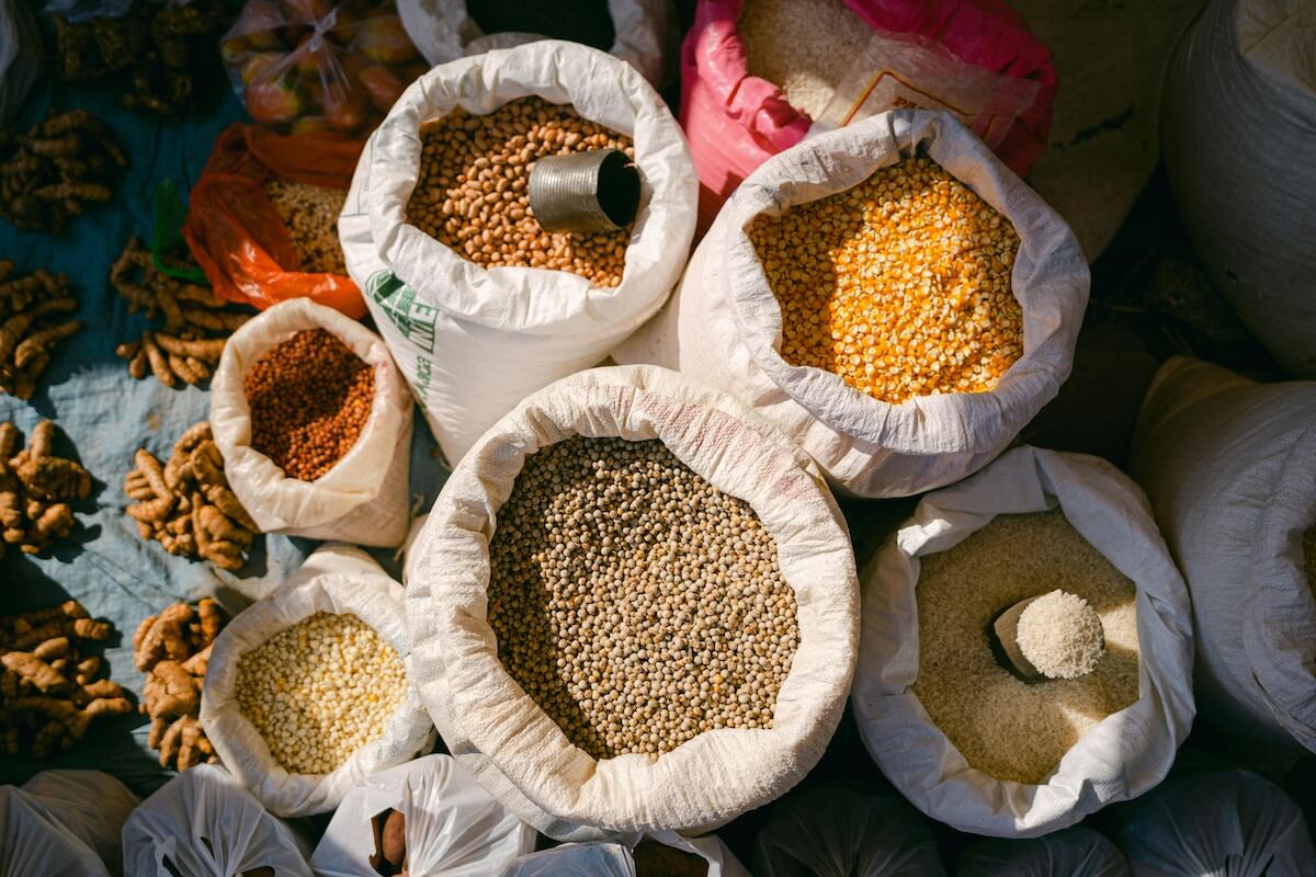 Colorful market stall displaying bags of grains, spices, and dried goods at traditional bazaar