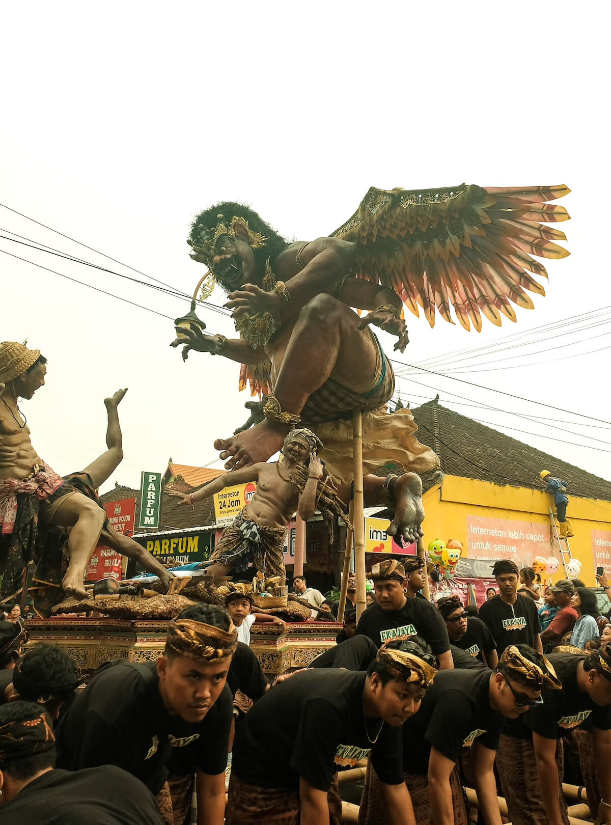 Men carrying a large ogoh-ogoh effigy through the street during Bali's Nyepi eve parade