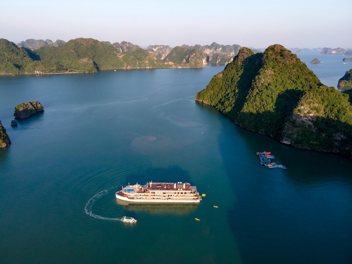 Cruise ship navigating through limestone islands in Halong Bay