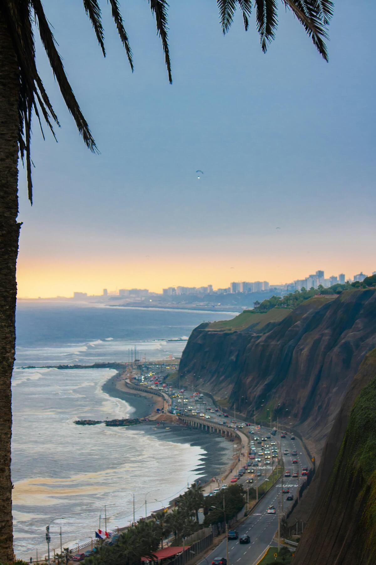 Lima's Pacific coastline at sunset with palm trees and ocean views