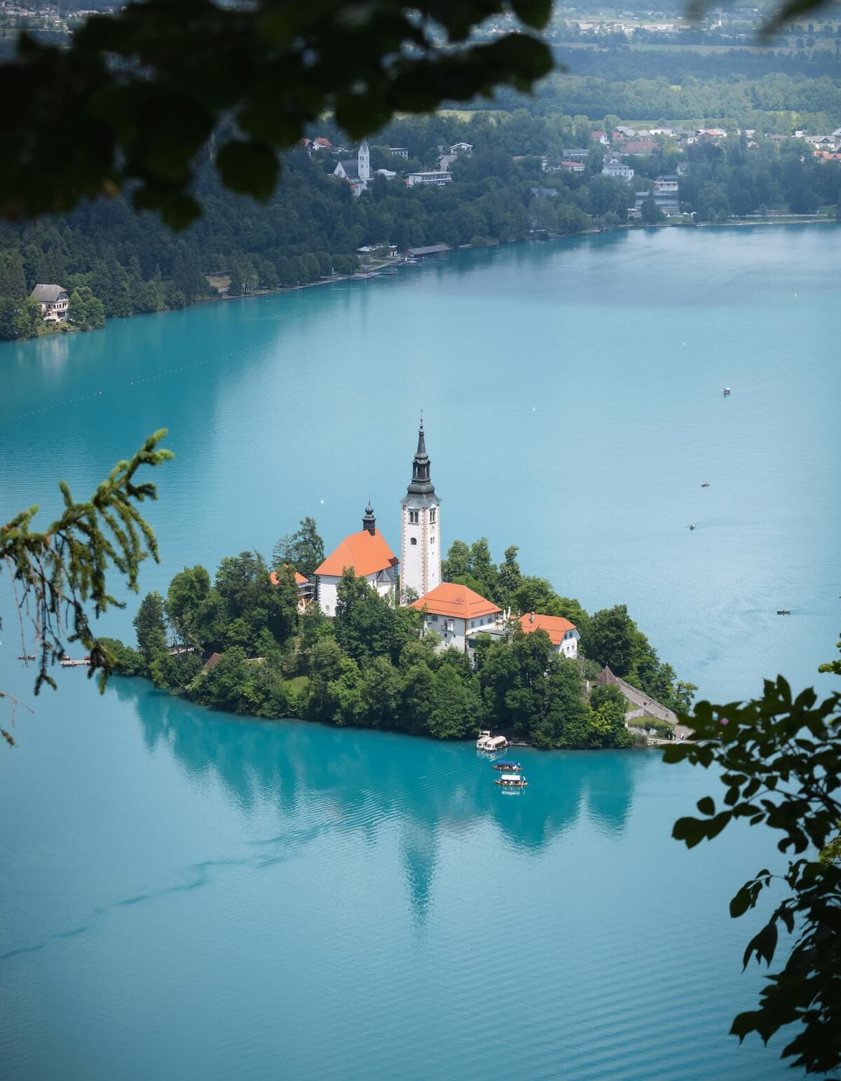 Aerial view of Lake Bled with island church and turquoise waters surrounded by forest