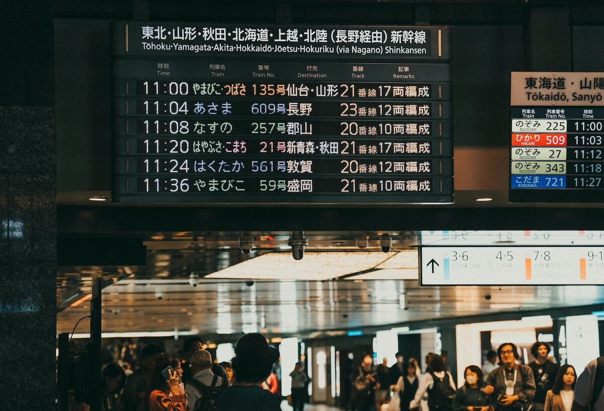 Japanese train station with digital departure board showing schedules