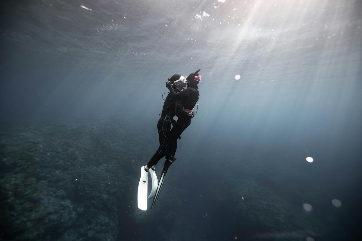 Diver swimming towards surface light in clear water