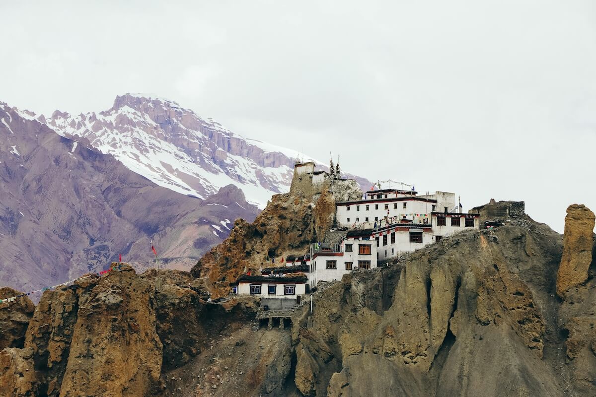 Monastery village of Spiti Valley with prayer flags and snow-capped peaks