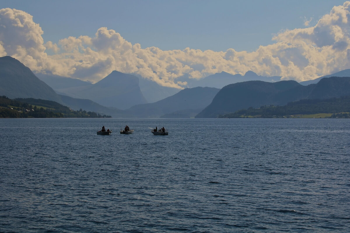 Serene Norwegian fjord with fishing boats and dramatic mountain backdrop