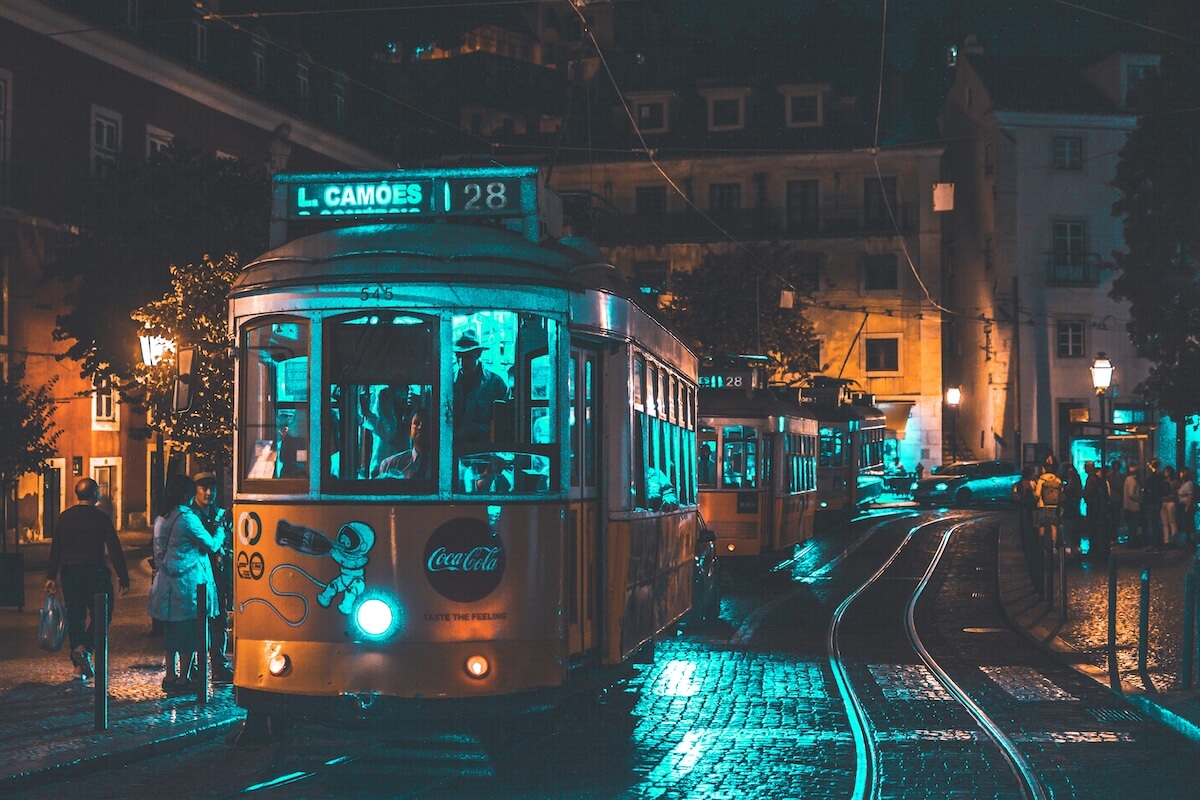 Illuminated vintage tram rides through Lisbon at night