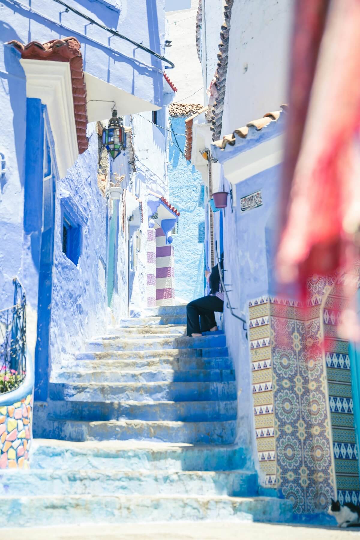 Blue-painted alleyway with stairs in Chefchaouen, Morocco