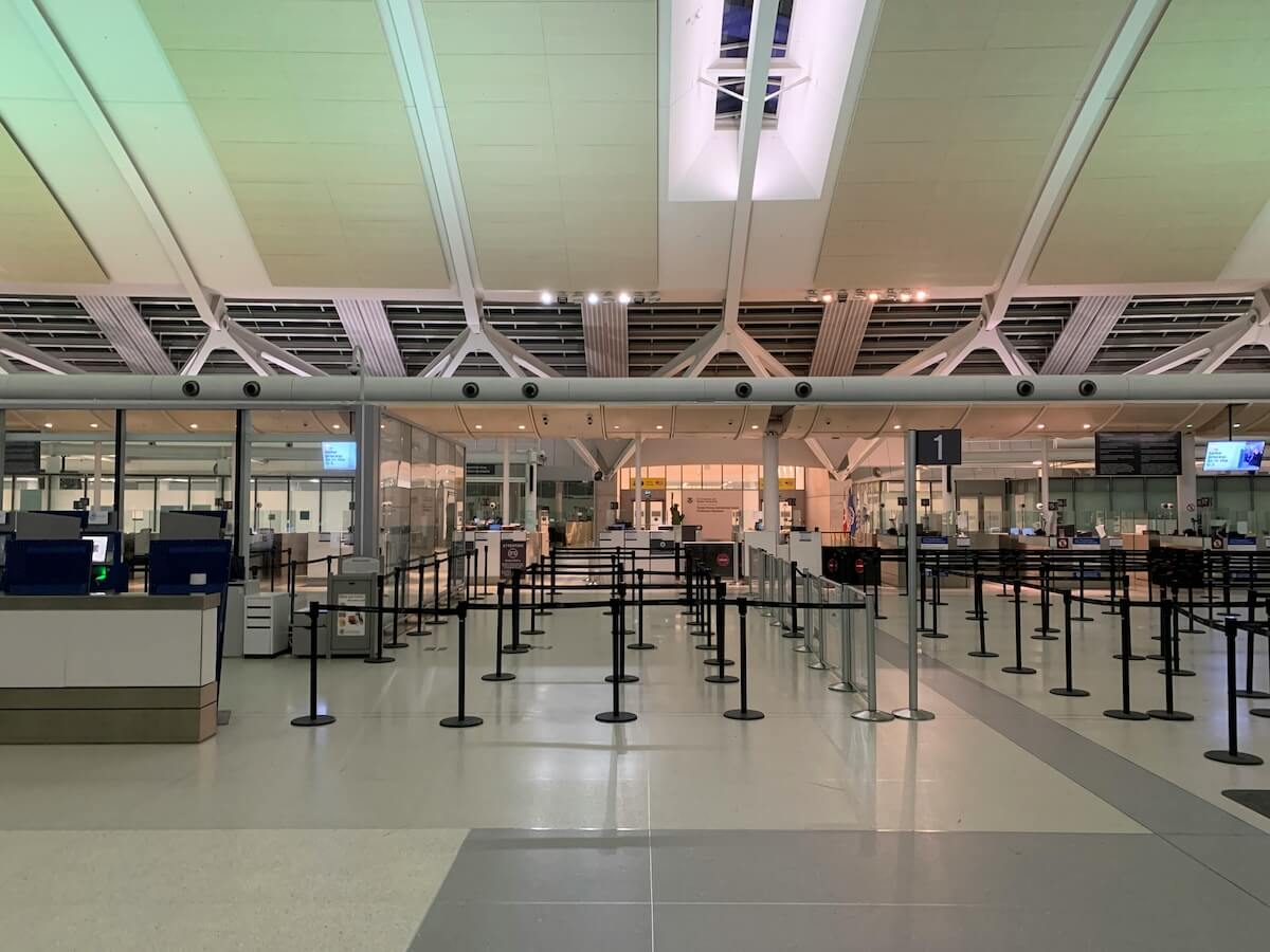 Airport terminal gates with departure board and bright lighting
