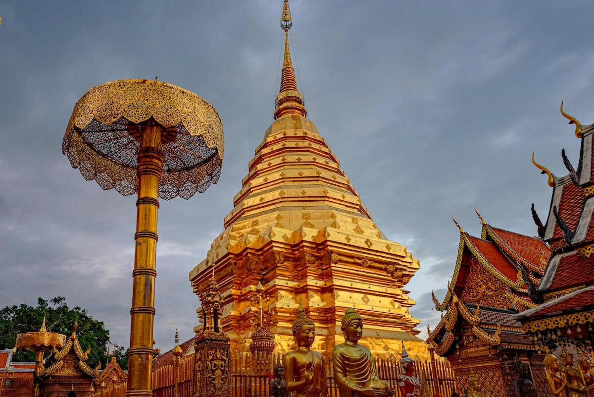 Golden pagoda of Wat Phra That Doi Suthep gleaming against a cloudy sky in Chiang Mai