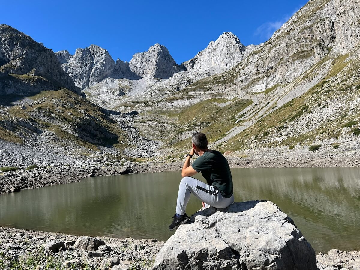 Hiker overlooking a mountain lake in the Albanian Alps